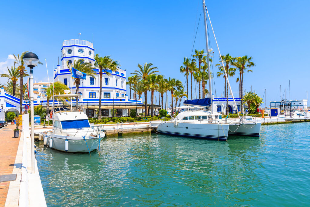 Estepona port with boats, palm trees and white buildings